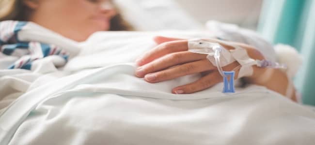 health insurance woman holding baby in hospital bed